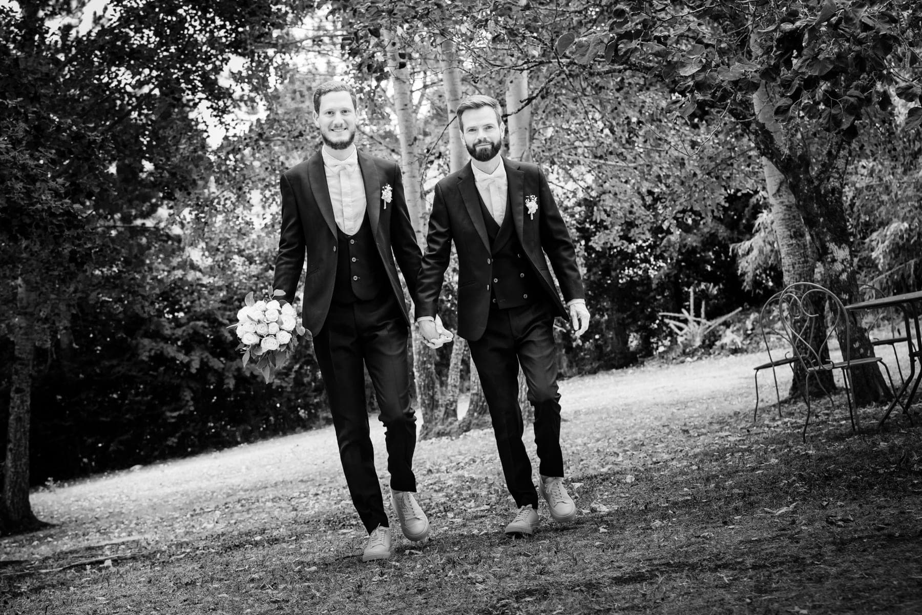 Deux mariés élégants marchant ensemble dans un parc — photographe mariage Montauban