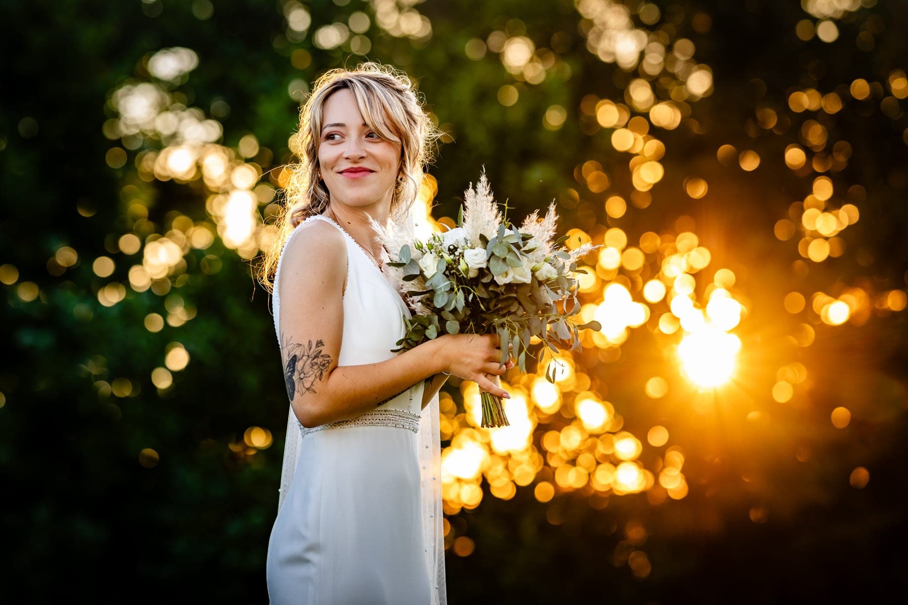 Mariée avec son bouquet au coucher du soleil, bokeh doré — photographe mariage Tarn-et-Garonne