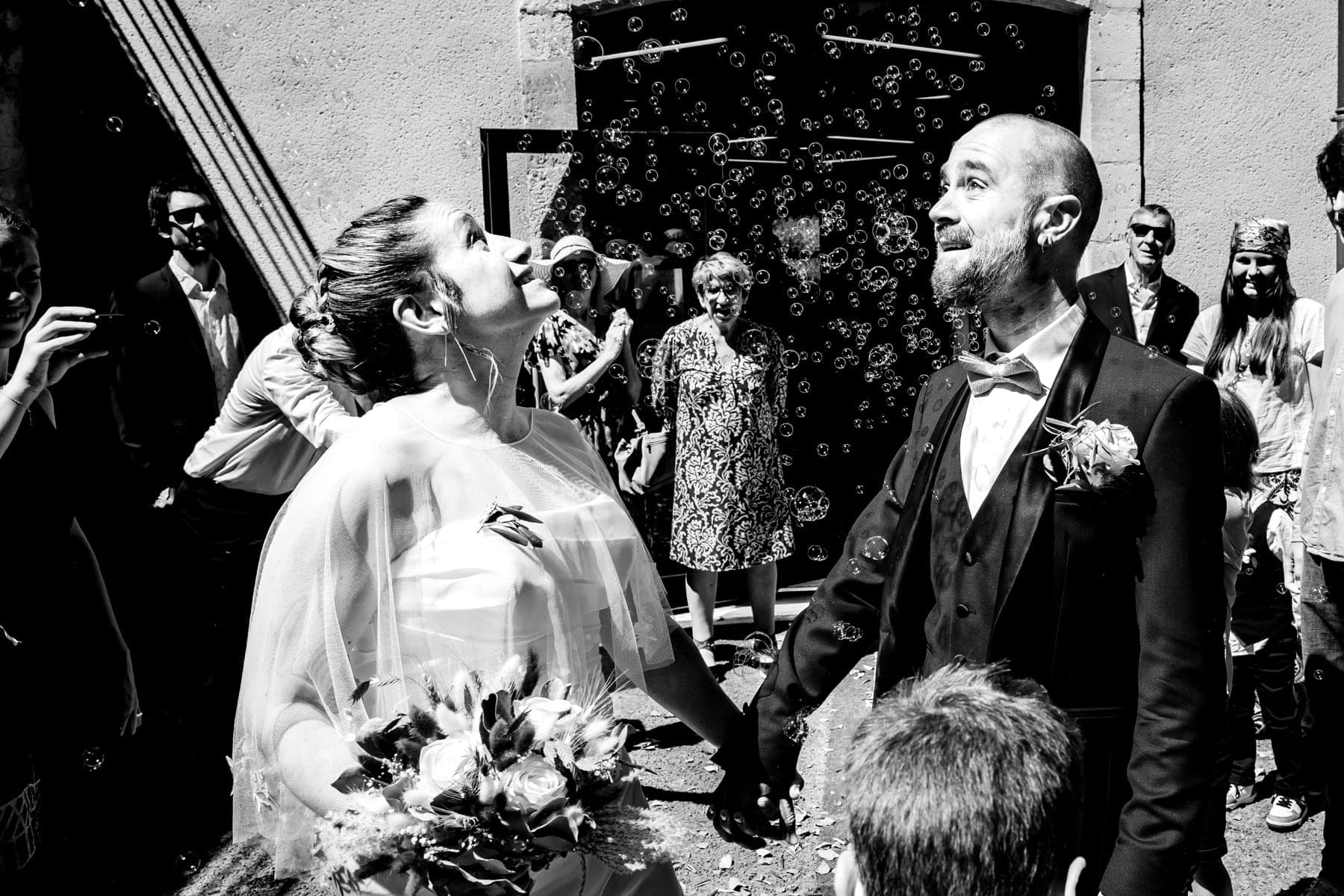 Mariée qui attrape des bulles de savon à la sortie de la cérémonie — photographe mariage 82