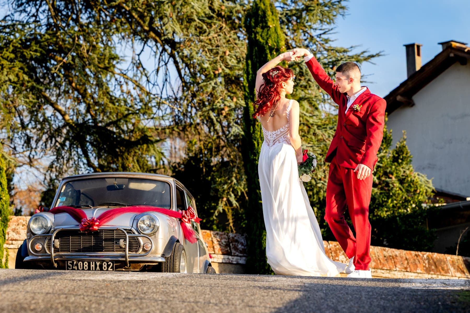 Couple qui danse près d'une Mini Cooper rouge — photographe mariage Montauban Occitanie