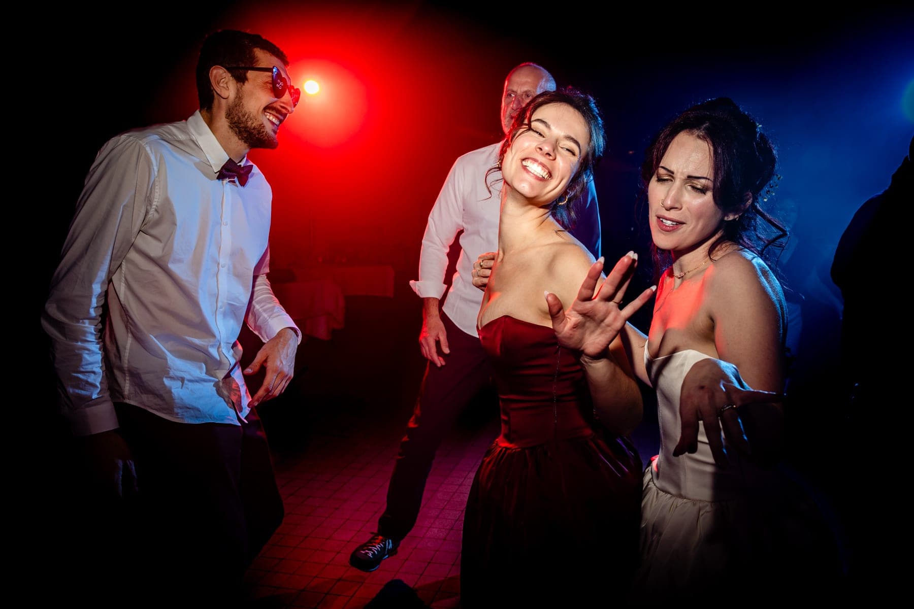 Invités déchaînés sur la piste de danse sous les lumières colorées — photographe mariage Montauban