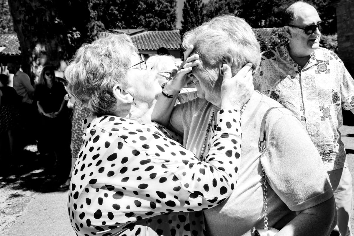 Émotion et tendresse entre deux invitées pendant un mariage en Occitanie photographié en noir et blanc