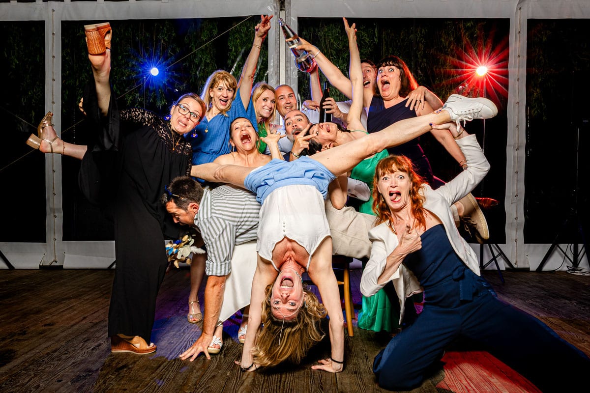 Photo de groupe de mariage fun et décalée avec invités en pleine fête sur la piste de danse
